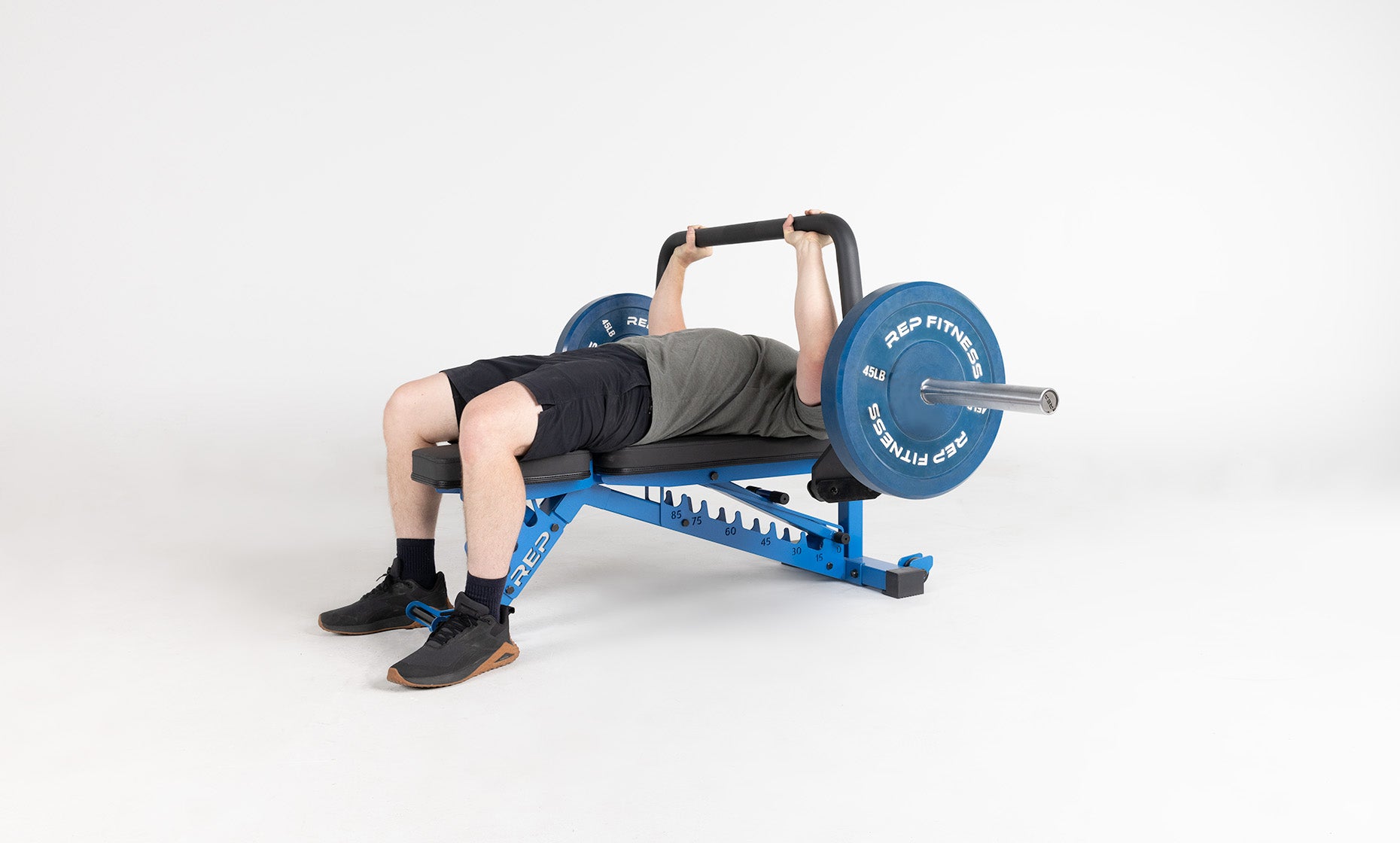 Lifter lying on a weight bench and performing a bench press using the Open Trap Bar without handles attached.